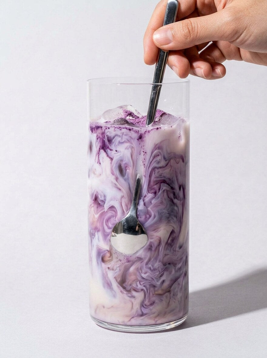 Hot violet ube latte in a white ceramic mug, morning light