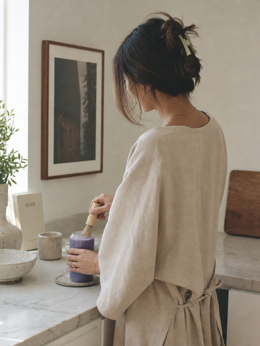 Woman preparing her morning violet ritual in a light-filled kitchen